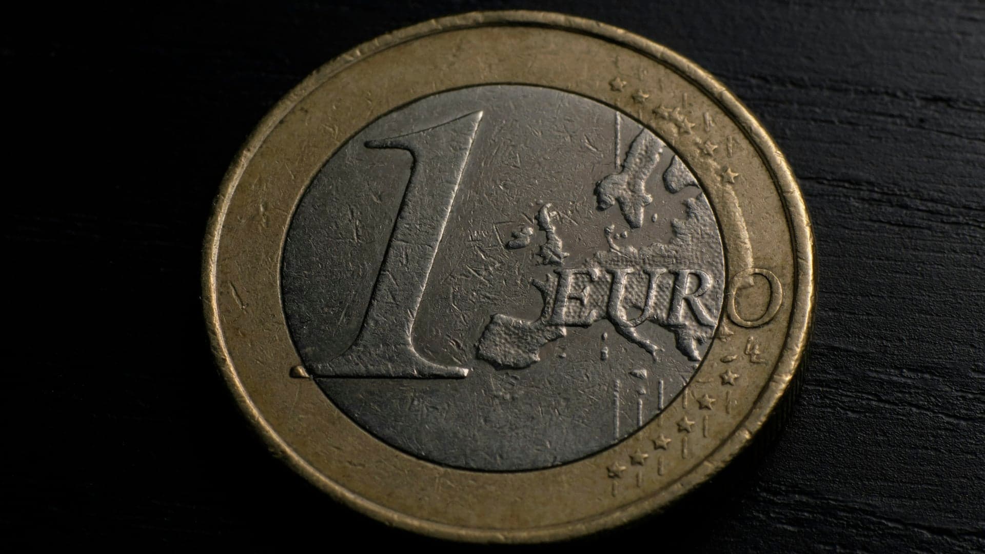 A one-euro coin on a dark background