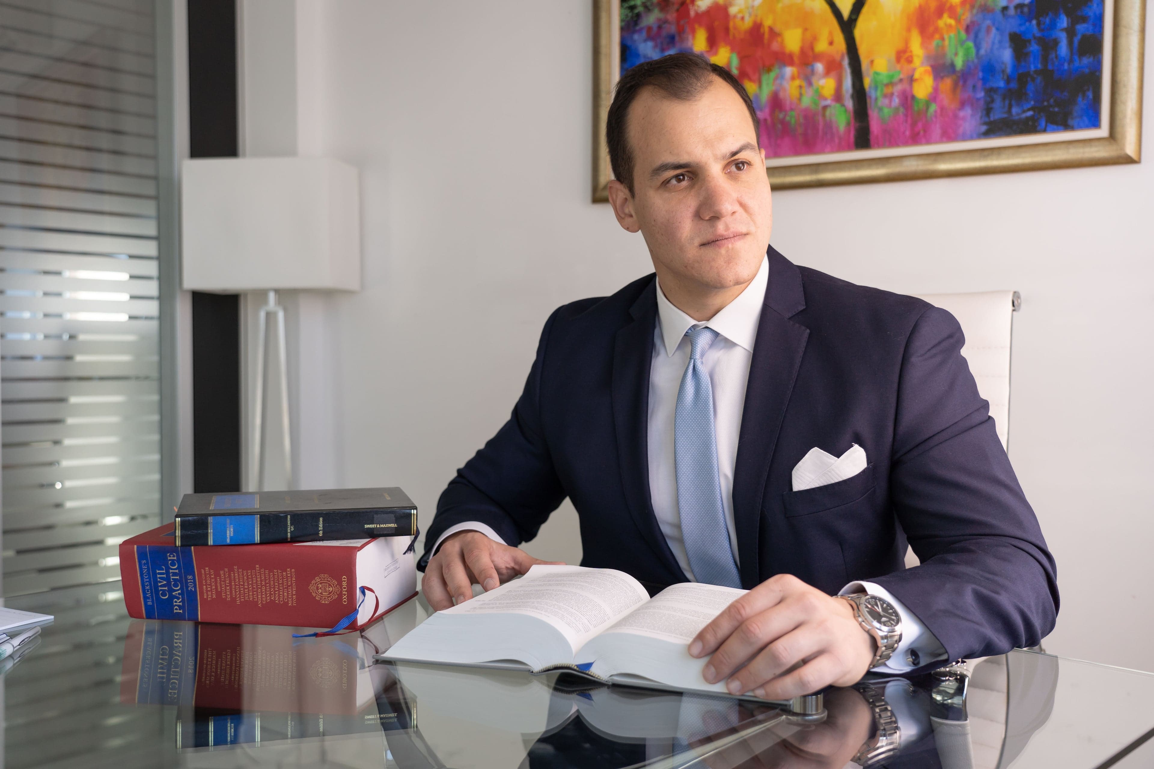 Christopher Lytras at his desk, with law books beside him